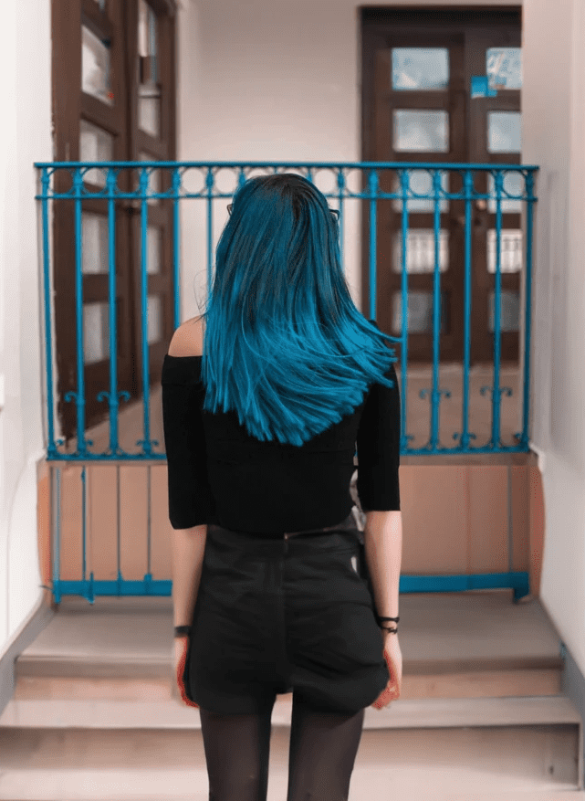 blue haired girl is standing
